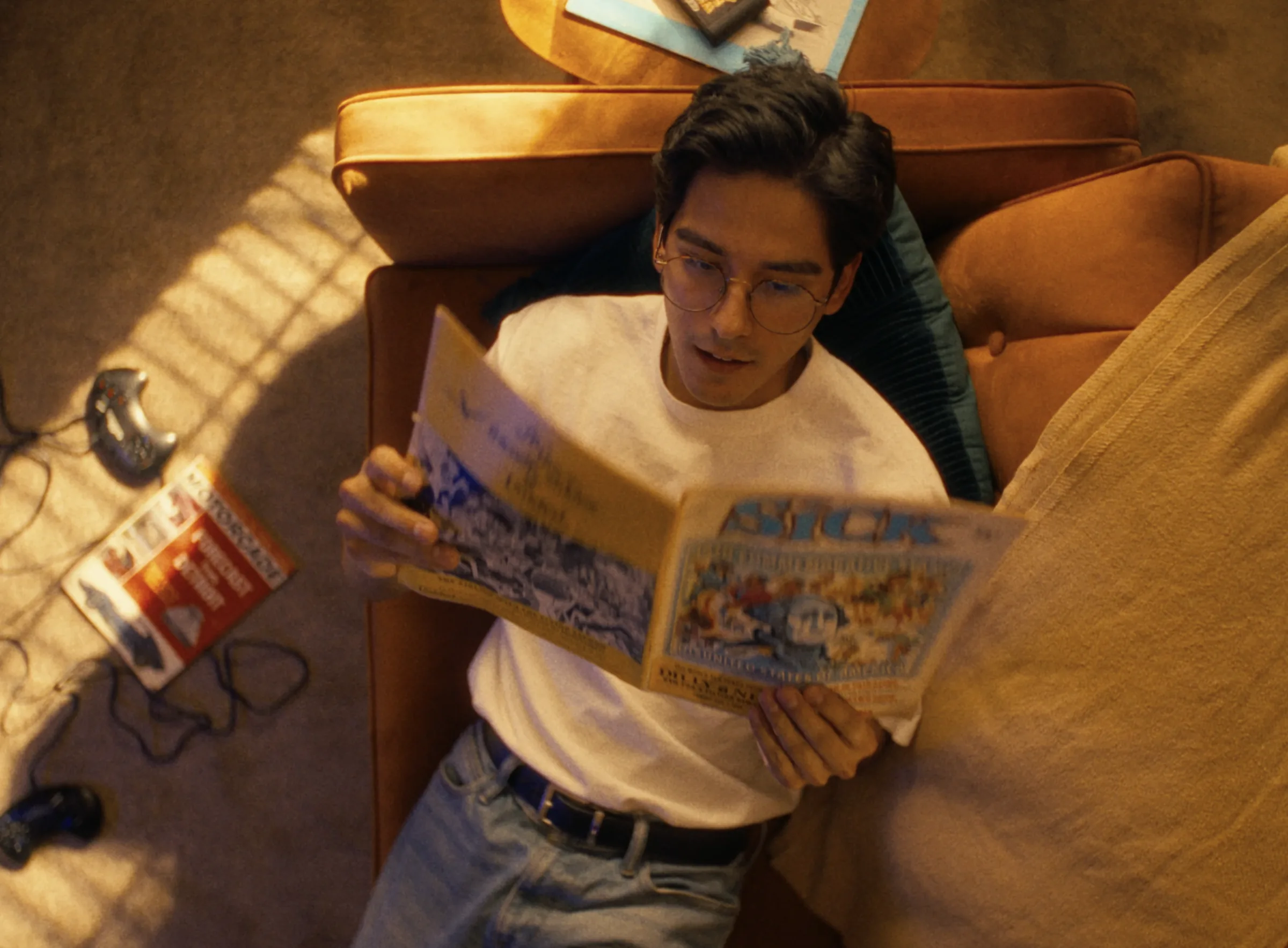 Musician reading a record sleeve on an ochre sofa